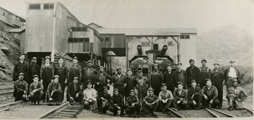 The large tipple stands behind the unidentified workers.