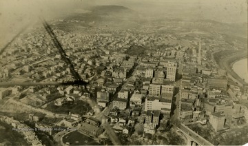Photograph taken from an airplane, part of the support piece for the wing can be seen on the left. The Marion County Courthouse is seen below, center right.