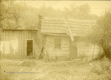 Unidentified children stand in front of the Scott Fortney Log Cabin. Located in Harrison County.