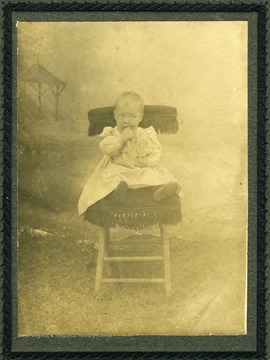 Toddler seated on a cushioned chair.