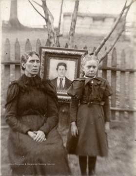 Flota Maud Bomer (Huffman) was the child of Sarah E. Summers Wolfe and William Bomer. The portrait in the photograph is Elijah Summers died in the battle of Cross Keys during the Civil War from sunstroke.