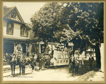 Information with the photograph, "Uniformed women on the decorated wagon are members of the Degree Team of the Ladies of the Maccabees of the World, Morgantown Hive No. 8." The location is possibly Spruce Street.