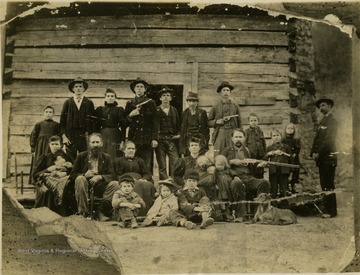 The William Anderson "Devil Anse" Hatfield family. Standing L to R: Rosada-daughter; Detroit (Troy)-son; Betty Hatfield Caldwell-daughter; Elias-son; Tom Chafin-nephew; Joe-son; Ock Damon-hired hand; Shephard-grandson (son of Cap); Coleman-grandson (son of Cap); Levicy Emma-granddaughter (daughter of Cap); Bill Borden-store clerk. Middle Row L to R: Mary Hensley Simpkins Howe-daughter with her child, Vici Simpkins; Anderson Hatfield; Levicy-wife of Anderson; Nancy Elizabeth-wife of Cap with her child Robert Elliott; Louise-daughter of Cap; William Anderson Jr. (Cap)-son. Front, seated on ground: Tennyson (Tennis)-son; Vicy-granddaughter (daughter of Johnse Hatfield); Willis-son; and Yellow Watch the dog.