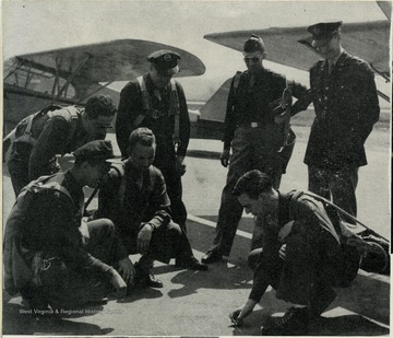 Air Corps Cadet/Student trainees from West Virginia University, gather around an instructor. Military training during World War II was accelerated on university campuses throughout the United States. At WVU, the Air Corps part-time training was replaced with a full time eight-week course. Other programs were also implemented such as the Army Specialized Training Program.