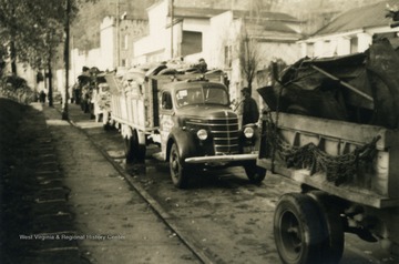 Scrap metal in the back of trucks roll through town. Scrap drives were prompted to involve citizens for morale purposes as well as helping the war effort.