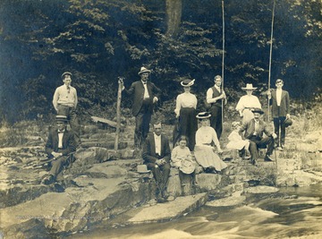Only identified member of the fishing party is Eva Dye Hathaway- young woman sitting center front wearing a hat.