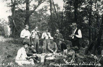 Expedition crew marking north-south boundary of West Virginia and Maryland take a break to eat dinner on the Mason Dixon line. (Standing up on right) Samuel Garnett, U.S. geological surveyer.