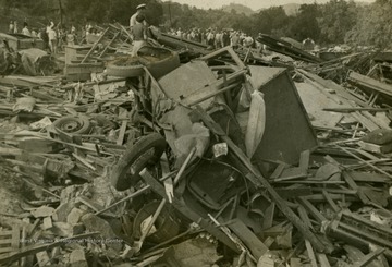 Man and woman stand on top of rubble that was caused by the deadliest tornado in West Virginia's history, which occurred on June 23, 1944.
