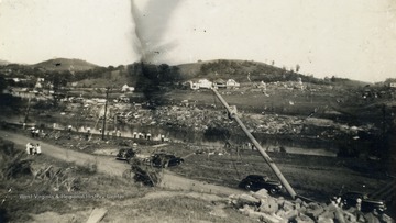 People gather along the West Fork River looking over to the hardest hit area by the tornado, Pleasant Hill, where no more than ten houses were left standing.