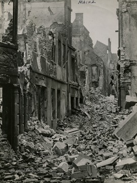 Information included with the photograph,"Debris spilled from bombed buildings of Mainz fills a street of the ancient Rhine River city captured by troops of the 80th Division, Third u.S. Army, March 23, 1945. Mainz, birthplace of Johannes Gutemberg, credited with the development of printing in the 15th Century, was a strategic Nazi manufacturing center of machinery and chemicals."