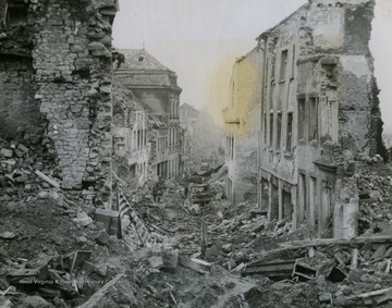 American GIs make their way through the rubble of what is left of a German town.