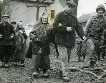 Information included on back: "Two Aged German women with civilian escorts are guided by a Ninth U.S. Army soldier (right, foreground) to Allied Military Government authorities in Erkelenz, Germany, for registration February 27, 1945, following capture of the town by Ninth Army forces driving toward the Rhine. Erkelenz is east of the Roer River, nine miles southwest of Munchen-Gladbach." (U.S. Signal Corps).