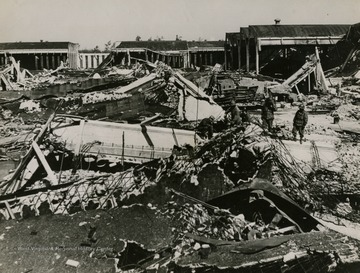 Information on the back of photo reads: "This is all that remained of the famous Nazi Volkswagen factory at Fallersleben, Germany, when U.S. Army ground forces captured the town following four daylight attacks on the plant by bombers of the Eighth U.S. Air Force and the British Royal Air Force. Prior to the attacks, 18,000 employees worked here but this figure fell to 7,000 after the first Allied visits. Later, work in the factory came to a complete halt. Only 40 workers were killed during the bombings because of air raid shelters. The plant was originally built by the Deutsche Arbeiter Front (German Labor Part) in 1938-39 to produce the "people's car", or Volkswagen, for sale to the German people at about 900 marks ($360). After it was completed, the German High Command converted it to jeep and mine production. Before the Allied air attacks, the plant was capable of monthly production of 1,800 kubelwagen (jeeps), 1,000 amphibious jeeps, 1,200 V-1 bombs, 100,00 Teller mines and the repair of 30 Ju-88 aircraft wings."