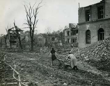 Information on back of photo reads: "German refugees with a cart move through the ruins of bombed Regensburg, captured by the 65th Division of the Third U.S. Army April 23, 1945. General George Patton's Third Army struck into the Southern German segment from the northwest to capture the Danube River town, which is about 70 miles from Munich."