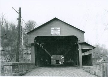 Sign on bridge in photograph reads: "Built by Eli and Lem Chenoweth 1852. Repaired by State Road Commission 1934."
