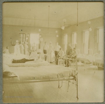 Several unidentified nurses and patients casually pose for this photograph in one of the hospital wards.