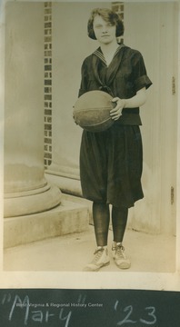 Player identified as "Mary" poses in uniform holding a basketball.