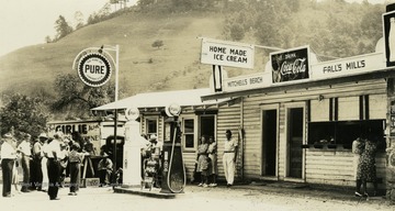 People gather outside of convenient store and gas station at Mitchell's Beach. (From postcard collection legacy system.)