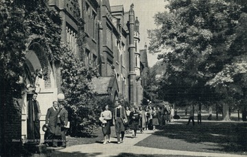 Students walking outside in front of the main campus building at Bethany College. Published by E.C. Kropp Company. (From postcard collection legacy system.)