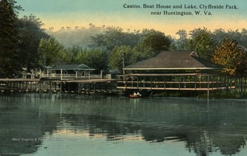 Two people relax on a boat near the docks. (From postcard collection legacy system.)