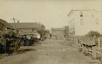A dirt road combs through the small town. See original for correspondence. (From postcard collection legacy system.)