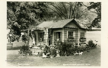 Small home covered in dolls and yard decorations in White Sulphur Springs, West Virginia. (From postcard collection legacy system.)