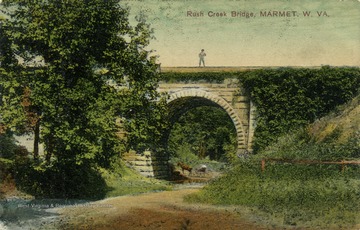 Man stands atop the Rush Creek Bridge with his horse and buggy parked beneath it. Published by J.F. Atkins. (From postcard collection legacy system.)