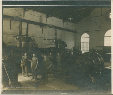 Five workers stand among the machinery at the Kingwood Power Station. (From postcard collection legacy system.)