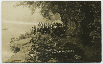 Unidentified group of men pose on the river bank. (From postcard collection legacy system.)