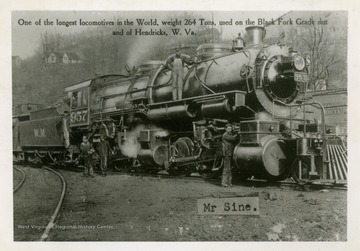 Weight of locomotive is 264 tons. Mr. Sine stands at the front of the locomotive along with several other workers. Published by West Virginia Photo Company. (From postcard collection legacy system.)