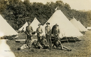 Group of soldiers pose in front of tents. (From postcard collection legacy system--subject.)