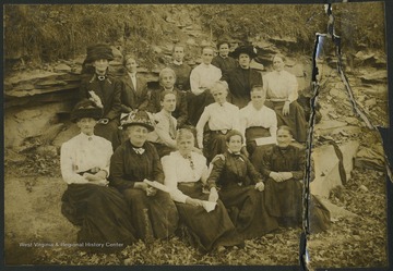 A group of women sitting in a field. See original for full photo roster. 