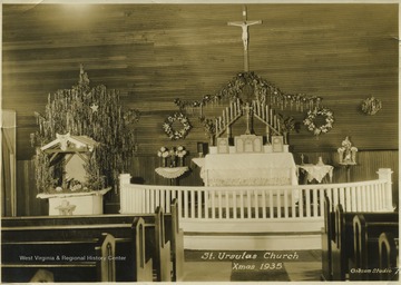 View of the church's interior on Christmas Day. A manger scene can be seen on the left while the rest of the church is ornamented in wreaths and other Christmas decorations. 