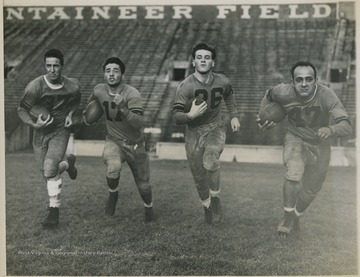 Photo description reads, "Starting backfield for West Virginia University eleven for their Nov. 2 game with Army at the United States Military Academy at West Point runs through practice at Morgantown, W. Va. The quartet (left to right) comprises: Jim Devonshire, Pete Zinnaich, Russell Combs, and Guido DeVeechis."