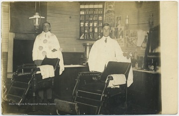 Inside the shop await two barbers who pose by their chairs. 