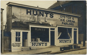 John Hunt's shop located on Spruce Street. To the bottom left is Sam Possener's shoe repair "while u wait". 