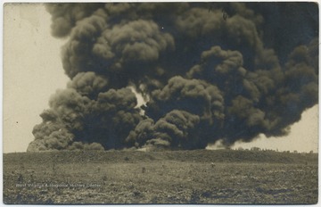 A billow of heavy, black smoke rises from the scene. 