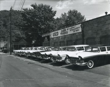 Photo of the car lot exhibiting Ford vehicles. 