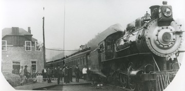 Unidentified passengers gather on the platform to board the train.