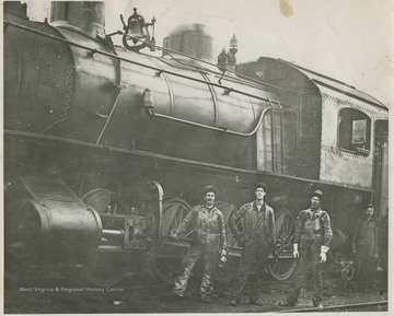 Unidentified workers pose by the train. 