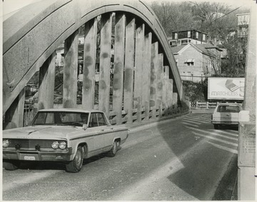 Automobiles drive across the bridge.