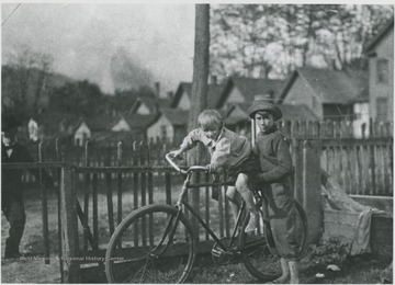 Henry &amp; Clinton pictured with a bicycle.