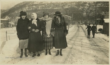 Miller and Gooche (2nd from right) pose with two other women on the snow covered street. Miller home pictured on the right. 