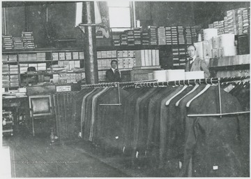 Interior view of what may possibly be the Lee Bailey Store. Two unidentified men are pictured behind a rack of suits.