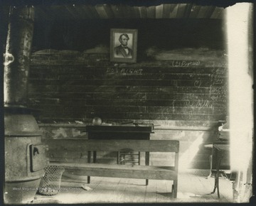 A look inside the presumed school house. A portrait of Abraham Lincoln hangs on the wall. 