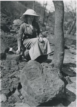 Whitman pictured sitting on a rock. 