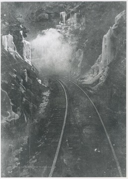 Railroad tracks run through the ice-covered mountains.