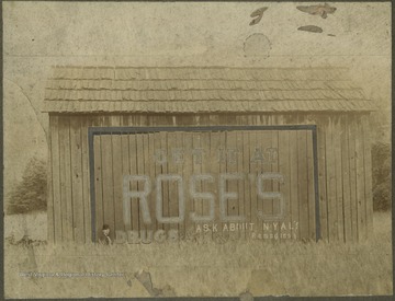Shan Rose pictured by the barn that advertises "Get it at Roses's Drugs--Ask about NYAL's Remdedies". The store is located at the intersection of Temple Street and 3rd Avenue.