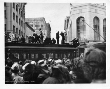 Civilians and Sailors perched the top of a trolley in San Francisco enjoying the celebration of Japan's surrender during World War II.
