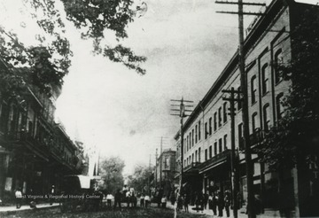 View from Summers Street. People line the sidewalks while a horse-drawn carriage makes its way across the road. Subjects unidentified. 